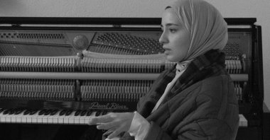 Büşra Kayıkçı talks in front of a piano. (AA)