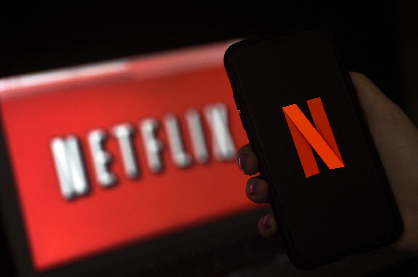 A computer screen and mobile phone display the Netflix logo in Arlington, Virginia, U.S., March 31, 2020. (AFP Photo)