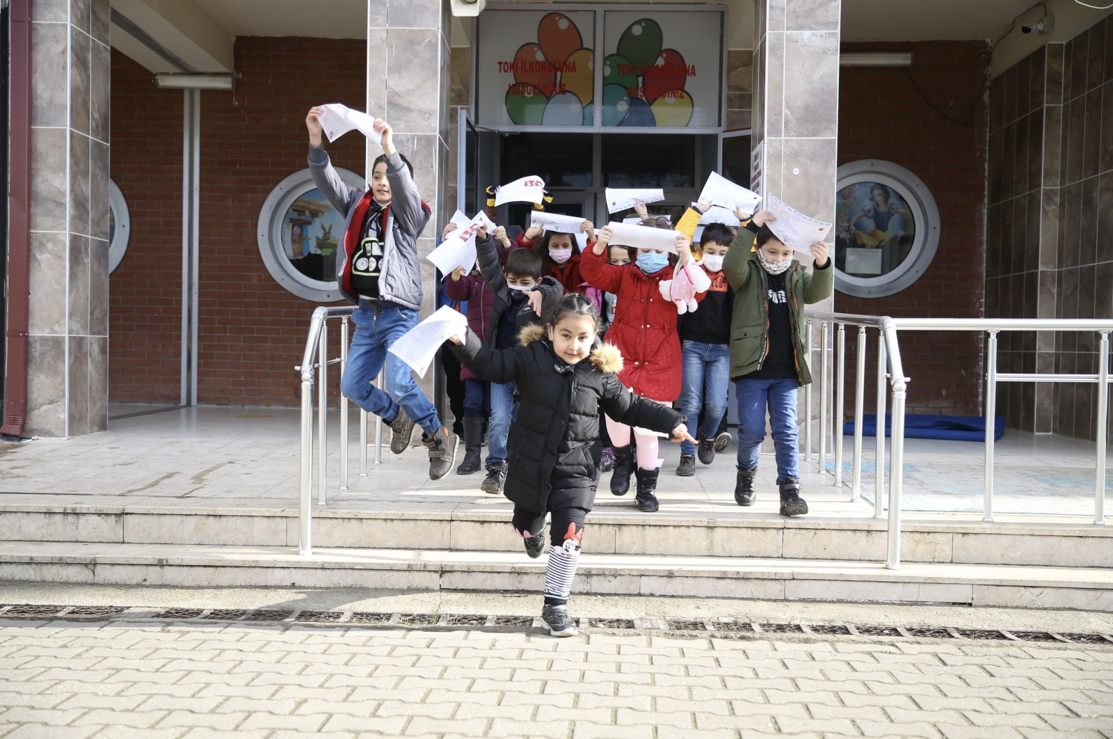 Students hold their report cards after leaving their school in Sakarya, northwestern Turkey, Jan. 21, 2022. (AA PHOTO)