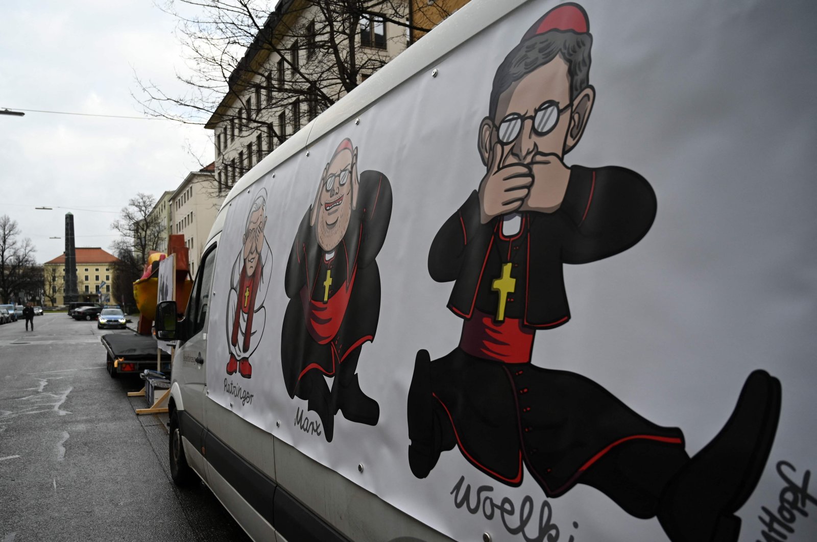 A placard features former archbishop of Munich and Freising Joseph Ratzinger (L), the current archbishop of Munich and Freising cardinal Reinhard Marx (C) and Cologne&#039;s archbishop, cardinal Rainer Maria Woelki (R), during a demonstration ahead of a press conference on a report on child sex abuse in the Archdiocese of Munich-Freising, on January 20, 2022 in Munich, southern Germany. (AFP Photo)