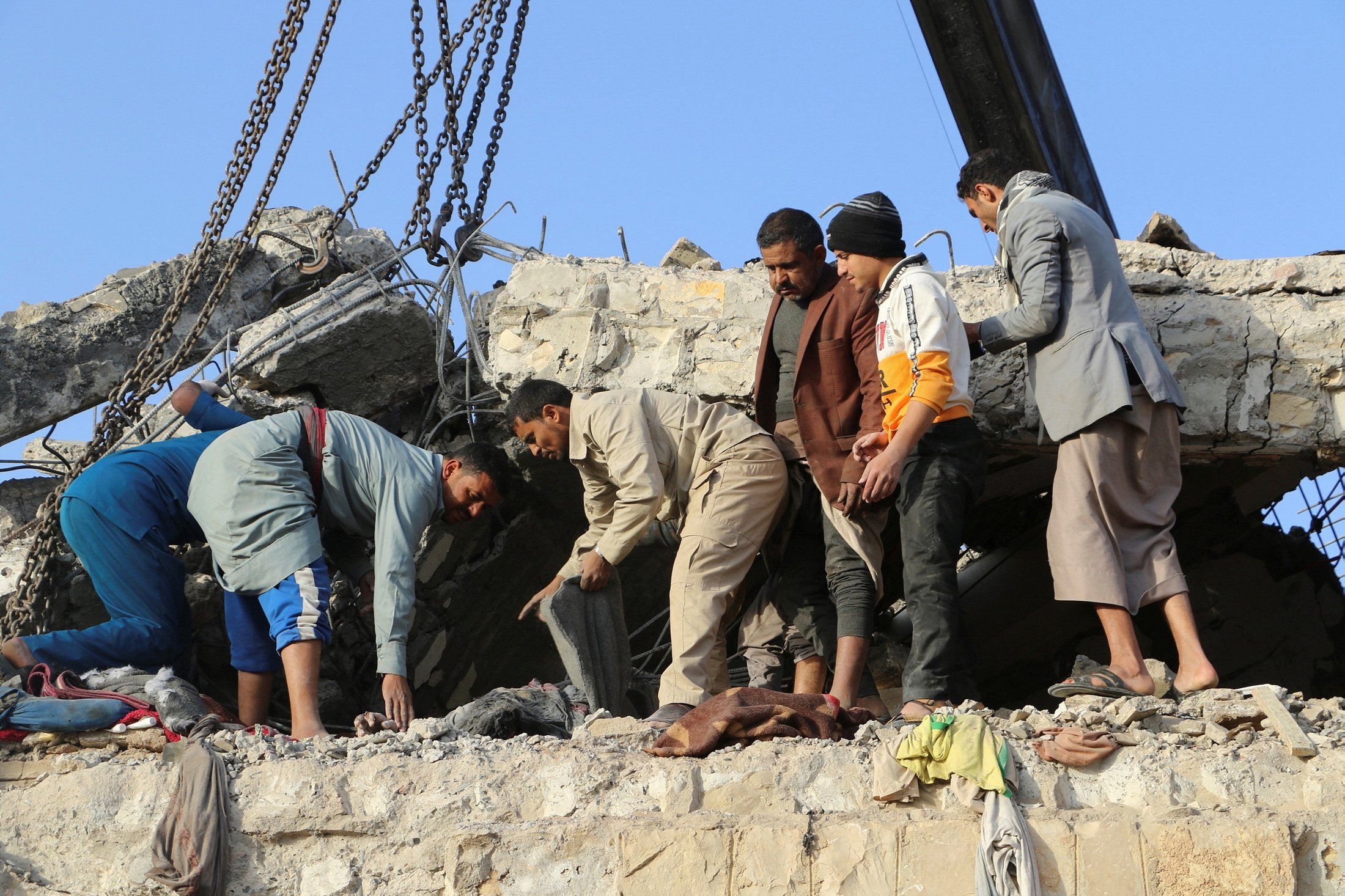 Les sauveteurs récupèrent le corps d'un homme sous le toit en béton effondré d'un centre de détention touché par des frappes aériennes à Saada, au Yémen, le 21 janvier 2022. (Photo Reuters)