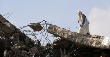 A man walks on the collapsed roof of a detention center hit by air strikes in Saada, Yemen, Jan. 21, 2022. (Reuters Photo)