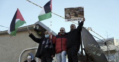 Israeli parliament member Ofer Cassif, center, waves a Palestinian flag at a protest in solidarity with Palestinian residents of the embattled Sheikh Jarrah neighborhood of east Jerusalem, occupied Palestine, Jan. 21, 2022. (AP Photo)