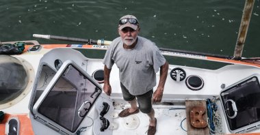In this file photo, Jean-Jacques Savin, a former paratrooper, 74, poses on his rowboat at a shipyard in Lege-Cap-Ferret, southwestern France, May 28, 2021. (Photo by Philippe Lopez / AFP)