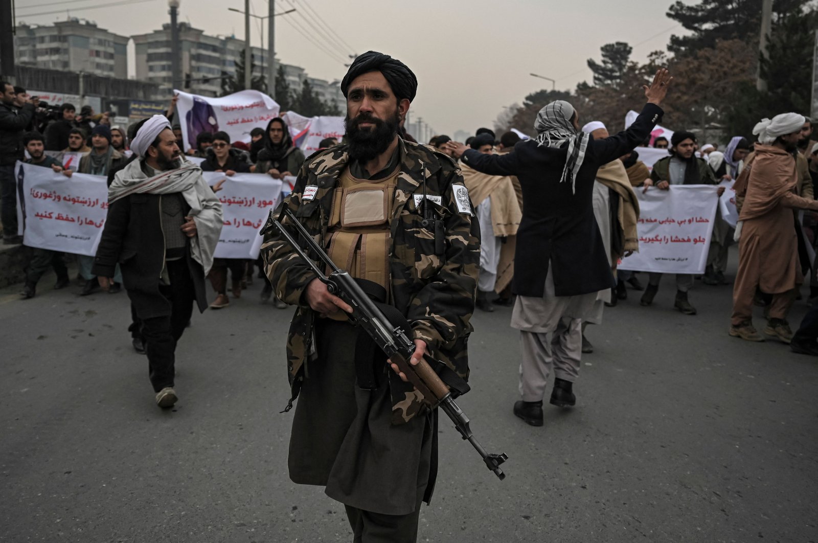 A Taliban fighter escorts people during a demonstration to condemn the recent protest by the Afghan women&#039;s rights activists, in Kabul, Afghanistan, Jan. 21, 2022. (AFP Photo)