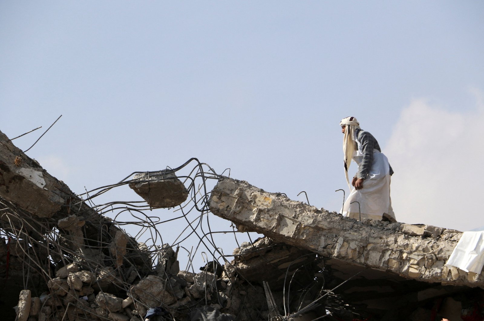A man walks on the collapsed roof of a detention center hit by air strikes in Saada, Yemen, Jan. 21, 2022. (Reuters Photo)