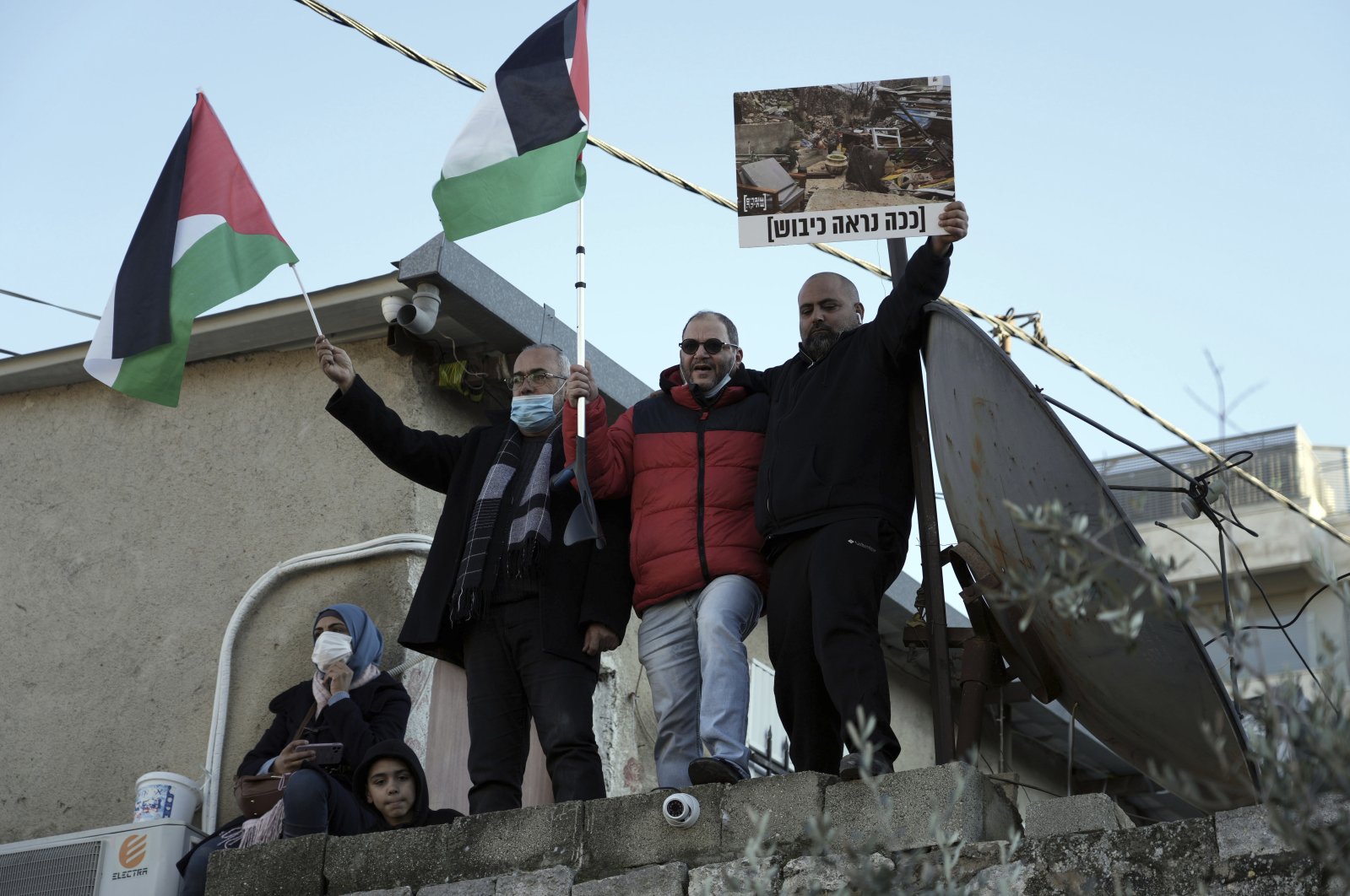 Israeli parliament member Ofer Cassif, center, waves a Palestinian flag at a protest in solidarity with Palestinian residents of the embattled Sheikh Jarrah neighborhood of east Jerusalem, occupied Palestine, Jan. 21, 2022. (AP Photo)