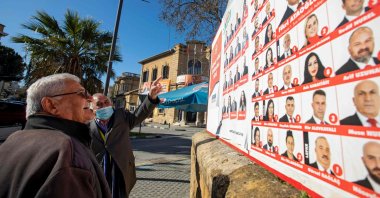 Men look at election posters in the capital Lefkoşa (Nicosia), Turkish Cyprus, Jan. 20, 2022. (AFP Photo)