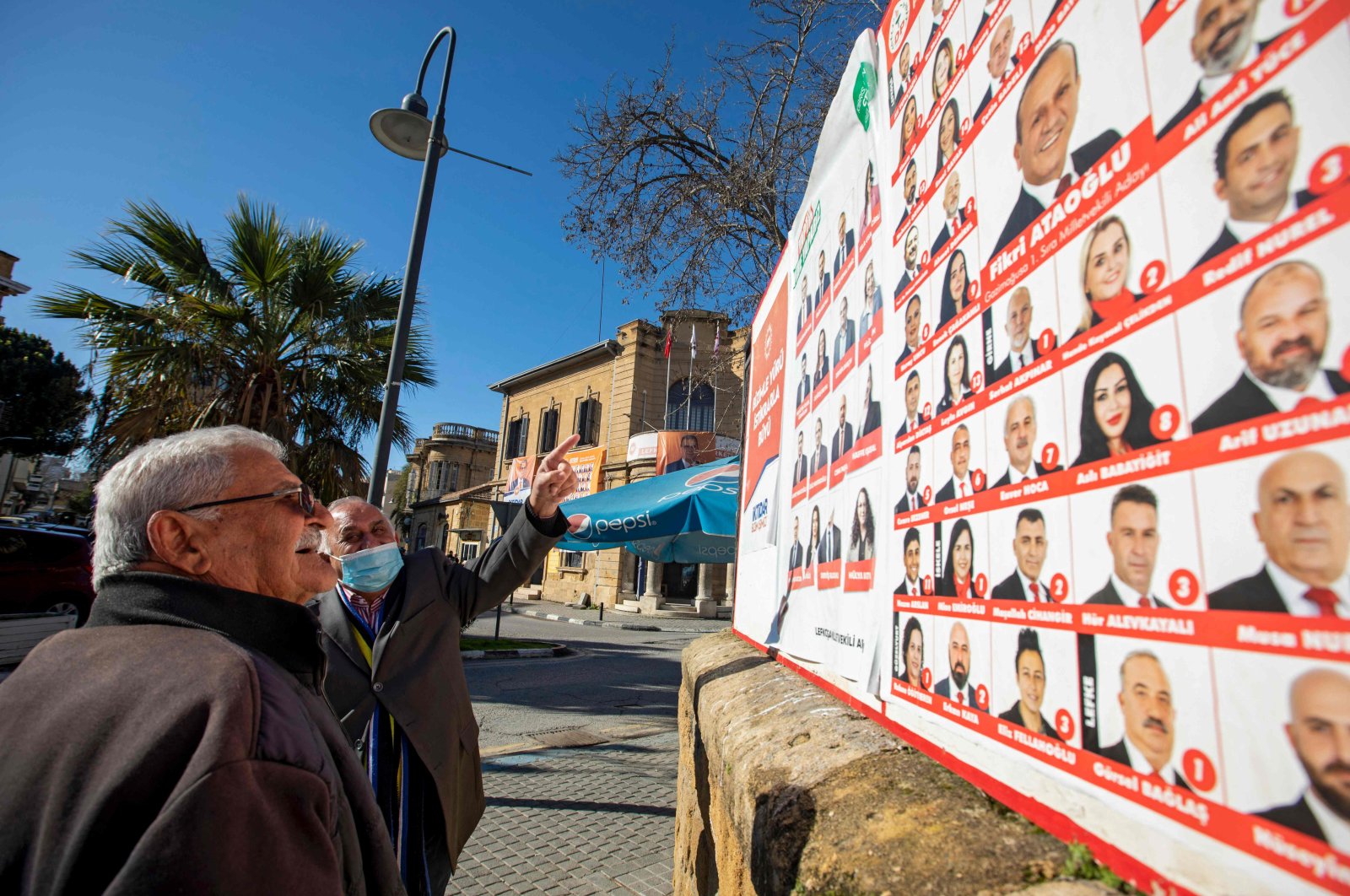 Men look at election posters in the capital Lefkoşa (Nicosia), Turkish Cyprus, Jan. 20, 2022. (AFP Photo)