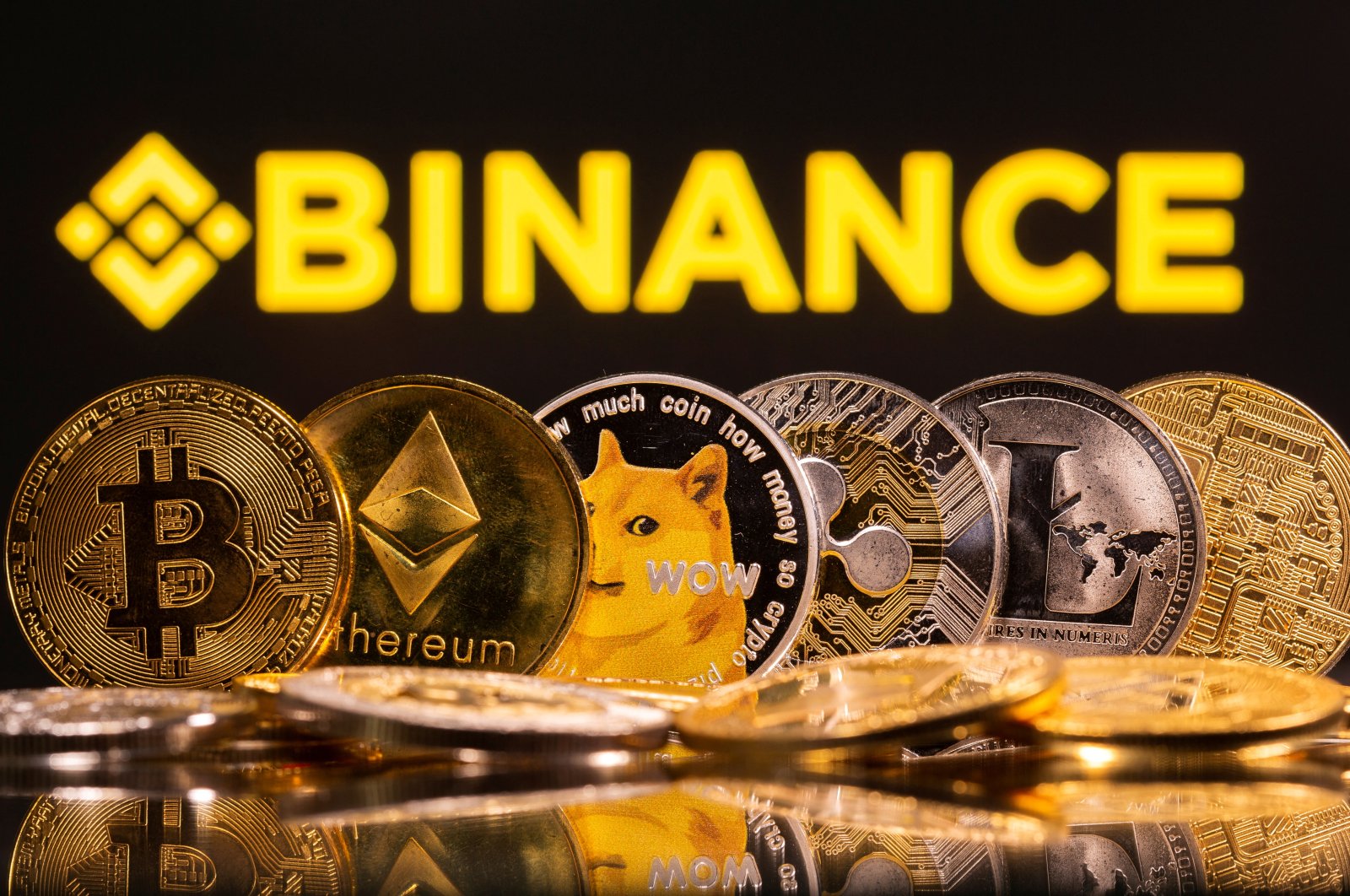 Representations of the cryptocurrencies Bitcoin, Ethereum, DogeCoin, Ripple and Litecoin are seen in front of a Binance logo in this illustration, June 28, 2021. (Reuters Photo)