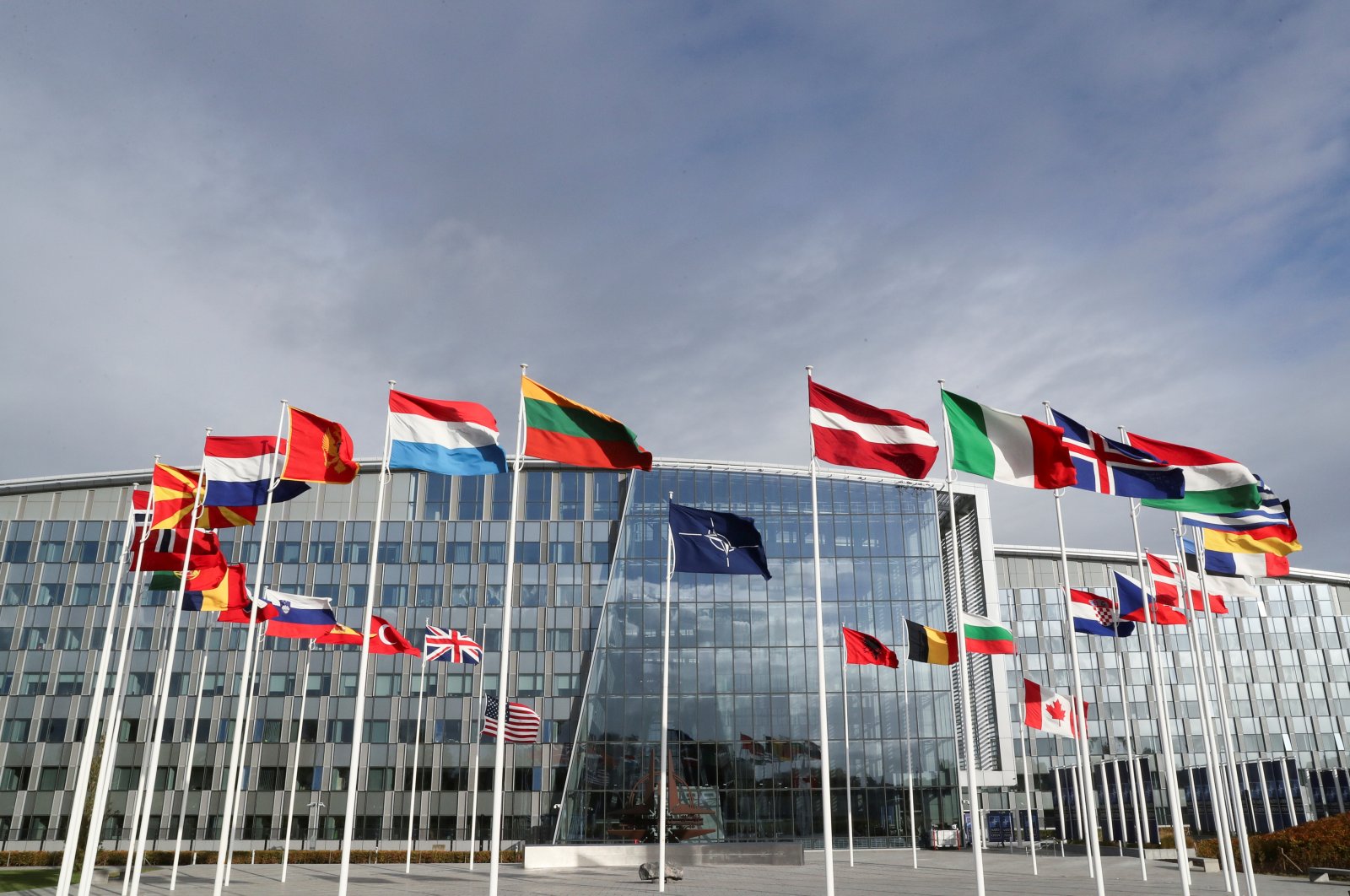 Flags wave outside the NATO headquarters ahead of a NATO defense ministers meeting, in Brussels, Belgium, Oct. 21, 2021. (Reuters Photo)