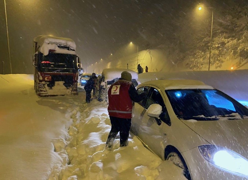 Awak Bulan Sabit Merah Turki mengantarkan makanan kepada pengendara yang terdampar di jalan raya tertutup, di Düzce, Turki utara, 24 Januari 2022. (AA PHOTO) 