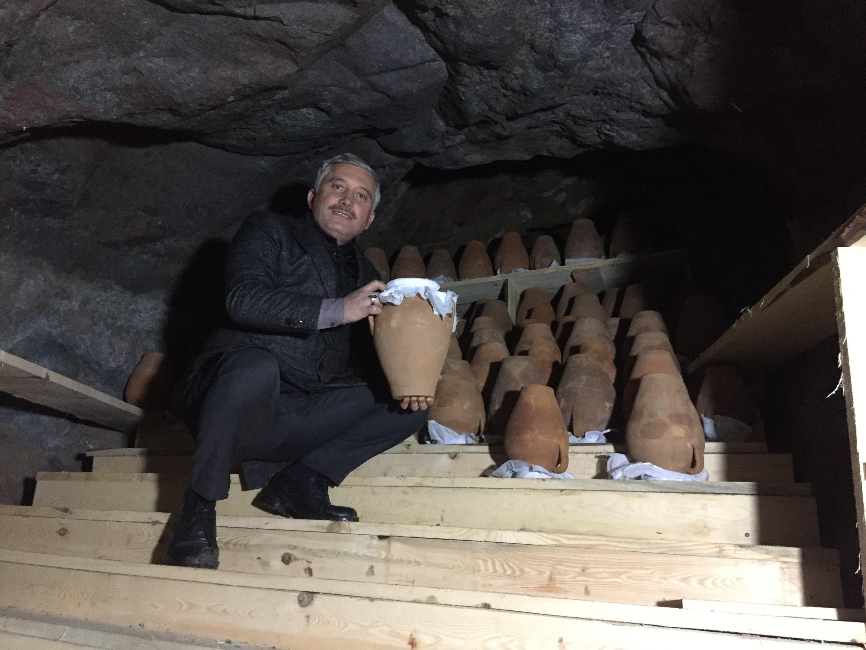 Walikota Mesudiye Isa Gül berpose dengan keju gilik yang diproduksi pemerintah kota, yang berusia di dalam sebuah gua, Mesudiye, Ordu, Turki, Jan. 22, 2022. (Foto AA)