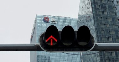 A partially removed company logo of China Evergrande Group is seen on the facade of its headquarters, near a traffic light in Shenzhen, Guangdong province, China, Jan. 10, 2022. (Reuters Photo)