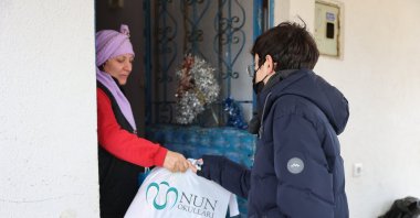 A student hands a bag full of donated clothes to a family in Beykoz, Istanbul, Turkey, Jan. 22, 2022. (Courtesy of NUN Schools)