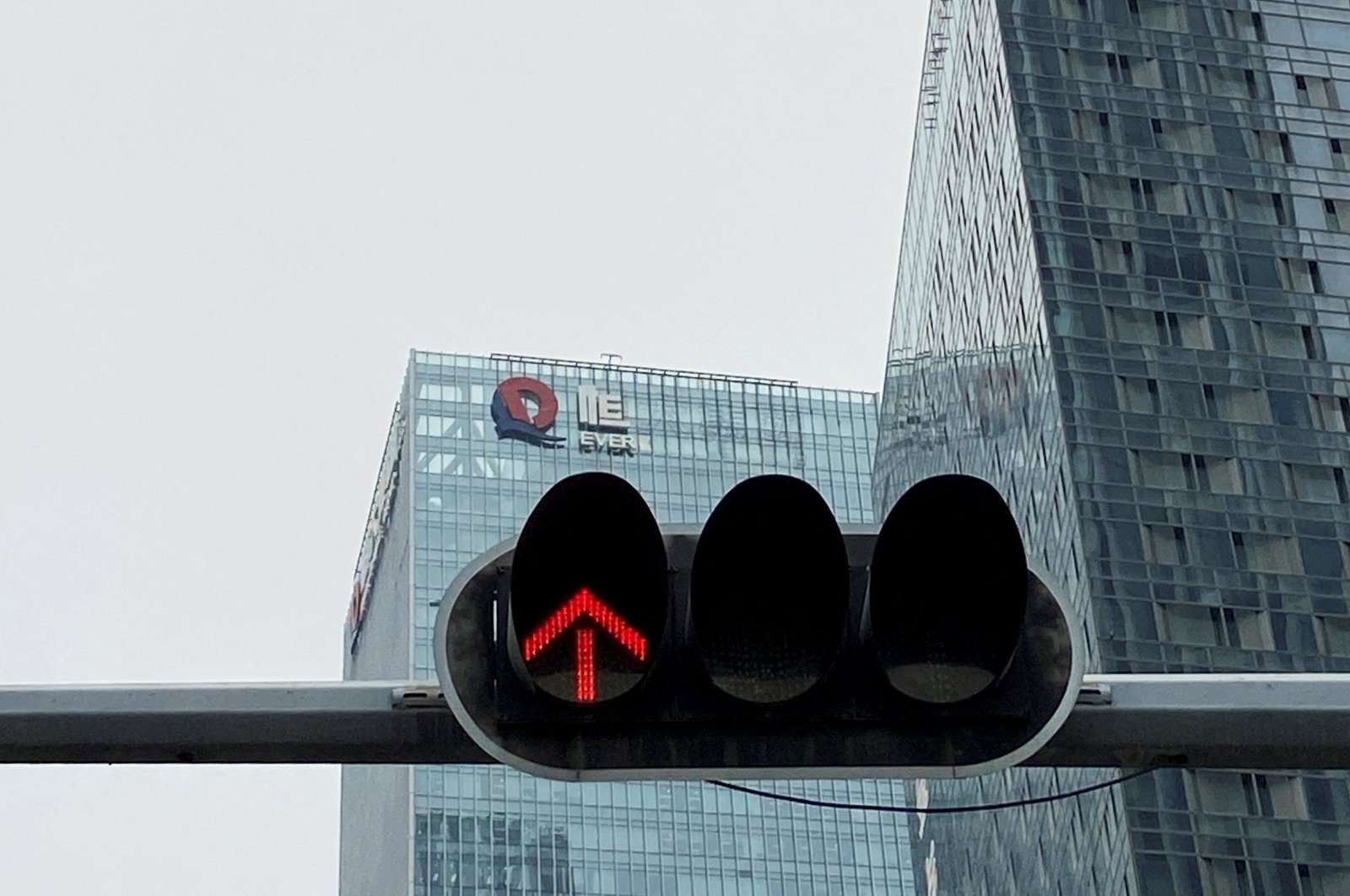 A partially removed company logo of China Evergrande Group is seen on the facade of its headquarters, near a traffic light in Shenzhen, Guangdong province, China, Jan. 10, 2022. (Reuters Photo)