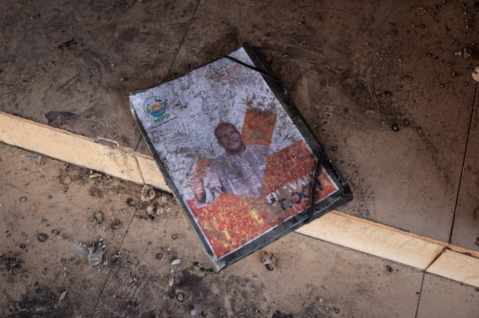 A burned poster is seen outside the Ruling People&#039;s Movement for Progress (MPP) campaign headquarters in Ouagadougou that was torched by a group of youth supporting the role of the army and opposed to President Marc Christian Kabore, Burkina Faso, Jan. 23, 2022. (AFP Photo)