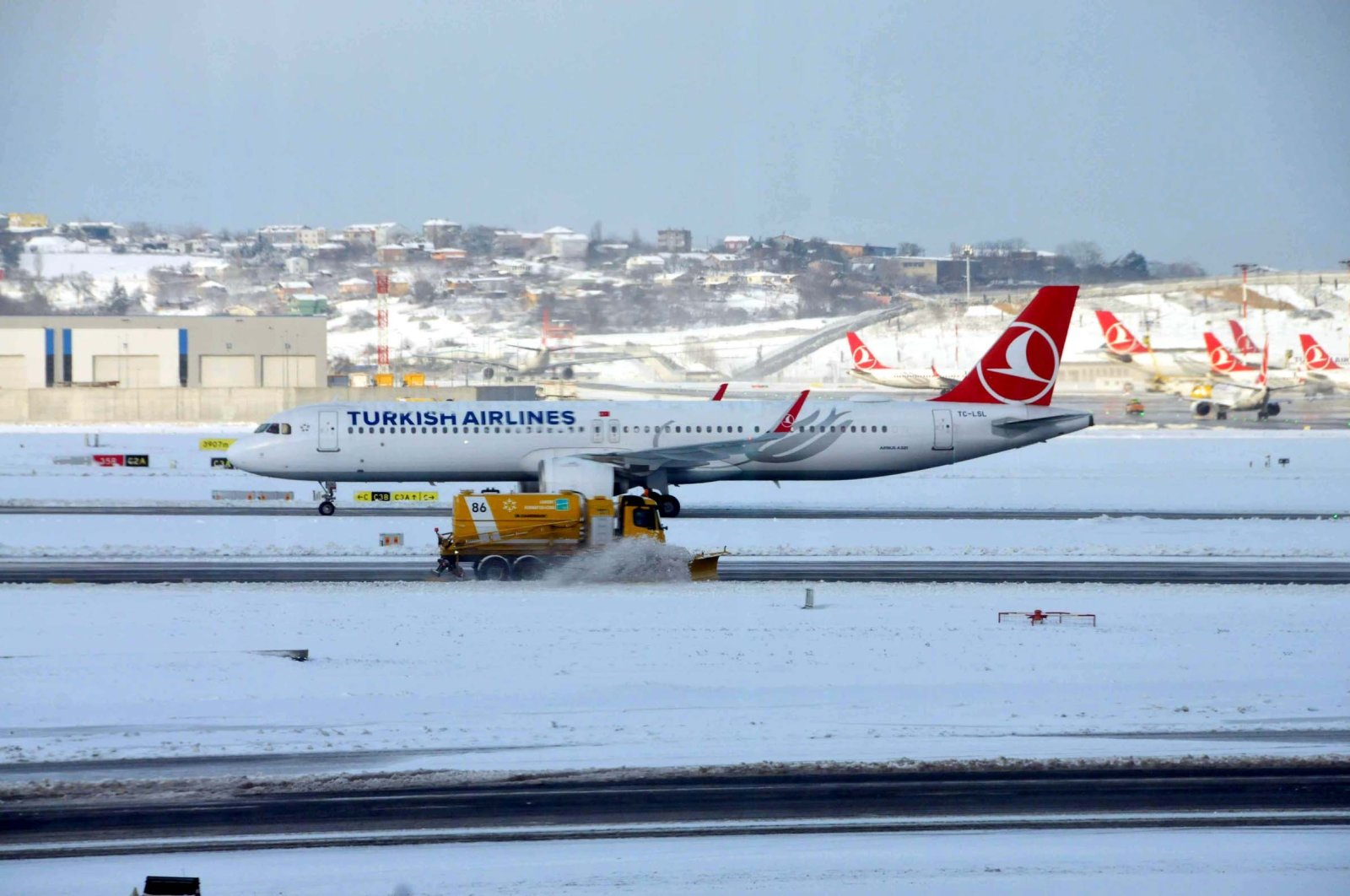 A Turkish Airlines aircraft is seen as snow plough cleans runway at Istanbul Airport, Jan. 24, 2022. (DHA Photo)