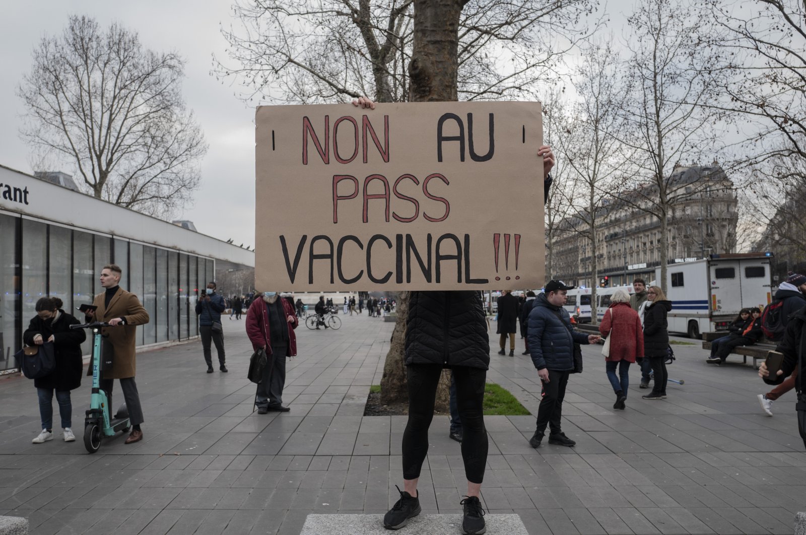 A demonstrator holds a placard that reads &quot;No to vaccine pass&quot; in opposition to COVID-19 vaccine passes and vaccinations, during a rally in Paris, France, Jan. 22, 2022. (AP Photo)