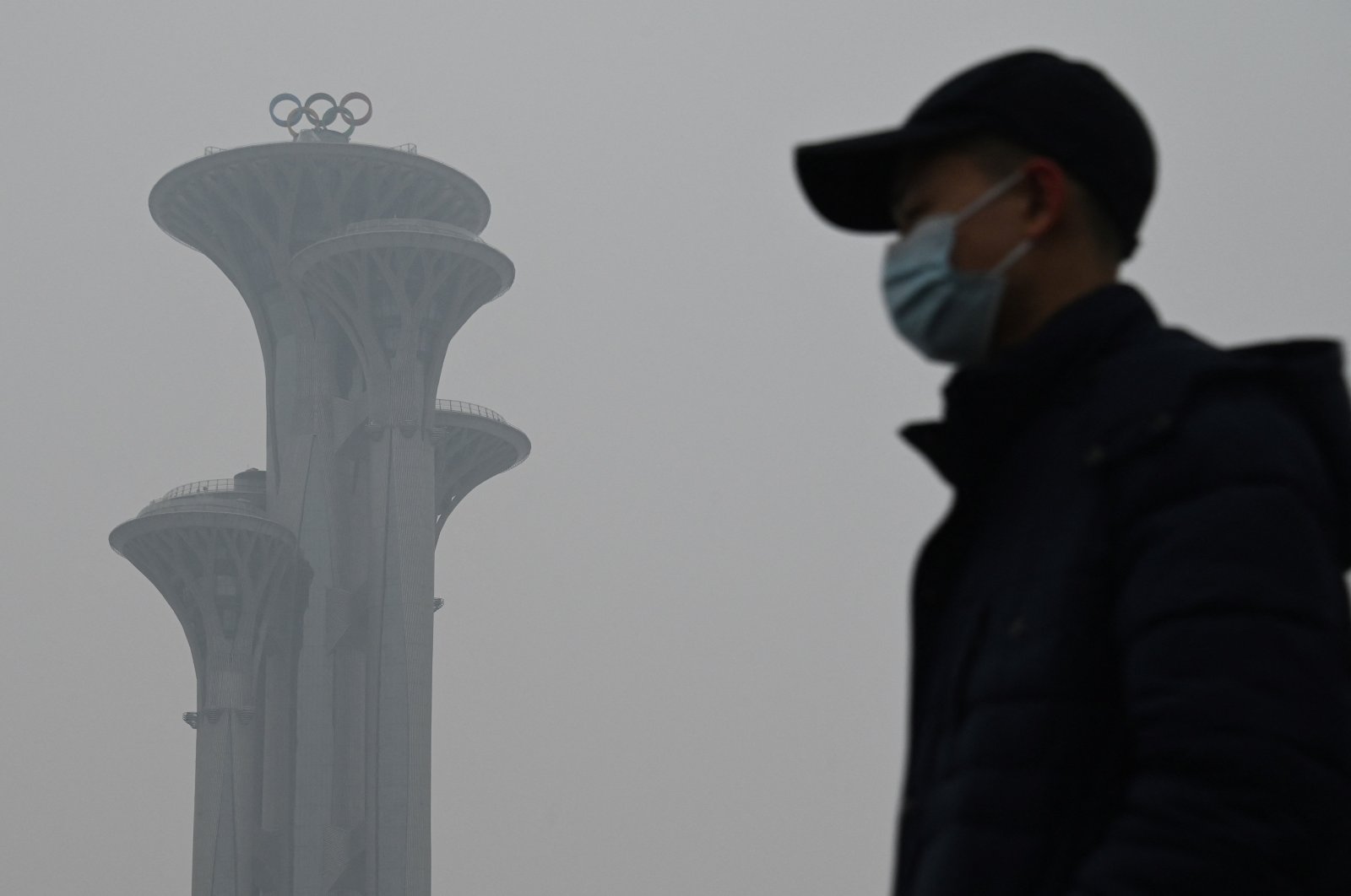 A man walks in the Olympic Park during a smoggy day in Beijing, China, Jan. 24, 2022. (AFP Photo)