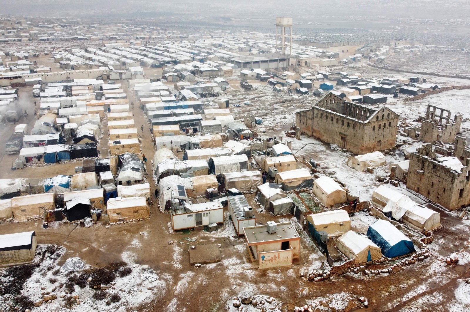 Tents and historical ruins are covered in snow at a camp for internally displaced Syrians, near the town of Kafr Lusin by the border with Turkey, in the opposition-held northwestern province of Idlib, Jan. 23, 2022. (AFP Photo)
