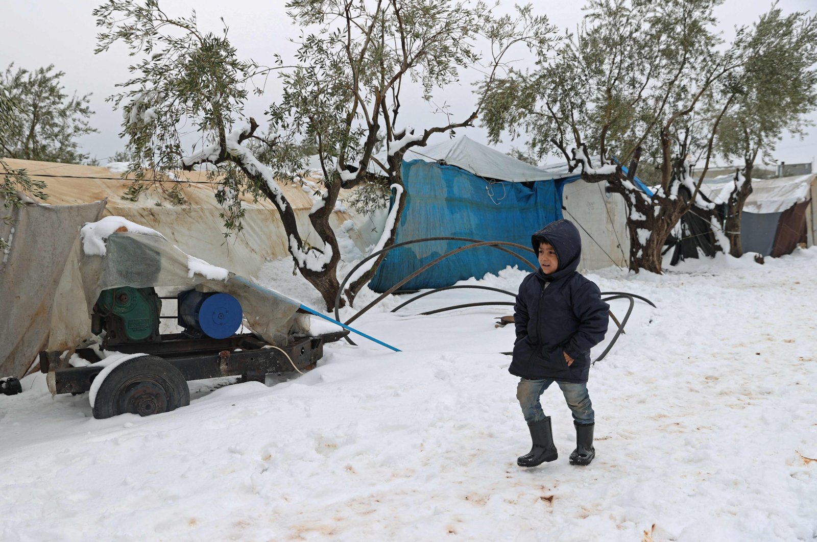 A boy walks in the snow at a camp for internally displaced people in the town of Azaz in the opposition-controlled northern countryside of Syria&#039;s Aleppo province, Jan. 23, 2022. (Photo by OMAR HAJ KADOUR / AFP)