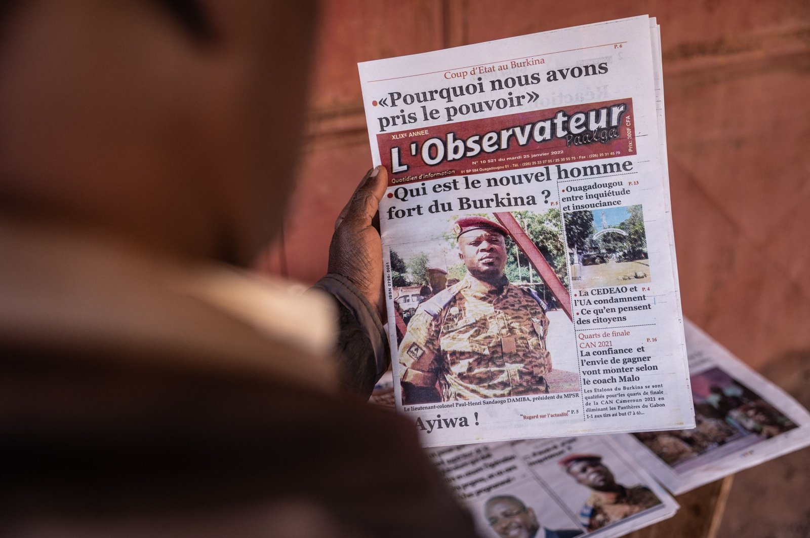 A man buys a newspaper featuring a picture of Paul Henri Sandaogo Damiba, the leader of the mutiny and the Patriotic Movement for the Protection and the Restauration (MPSR), in Ouagadougou, Burkina Faso, Jan. 25, 2022. (AFP Photo)