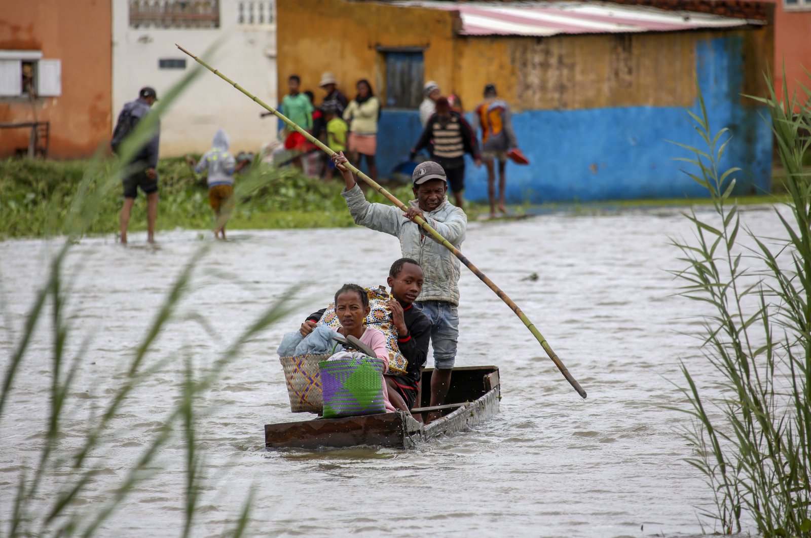 A family take their belongings after their home was flooded after a weeklong of heavy rain in Antananarivo, Madagascar, Jan. 24, 2022. (AP Photo)