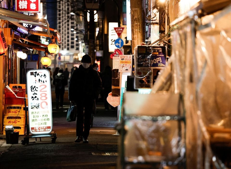 A passerby wearing a protective face mask walks at an izakaya pub alley amid the COVID-19 pandemic, Tokyo, Japan, Jan. 25, 2022. (Reuters Photo)