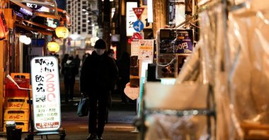 A passerby wearing a protective face mask walks at an izakaya pub alley amid the COVID-19 pandemic, Tokyo, Japan, Jan. 25, 2022. (Reuters Photo)