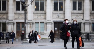 Women wearing protective face masks walk in front of Paris Town Hall, amid the rise of coronavirus cases due to the Omicron variant, in Paris, France, Jan. 25, 2022. (Reuters Photo)
