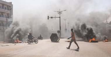 A man crosses through burning barricades in the central avenues in Ouagadougou where a group of young demonstrators supporting the role of the army protested against President Marc Christian Kabore, Burkina Faso, Jan. 23, 2022. (AFP Photo)