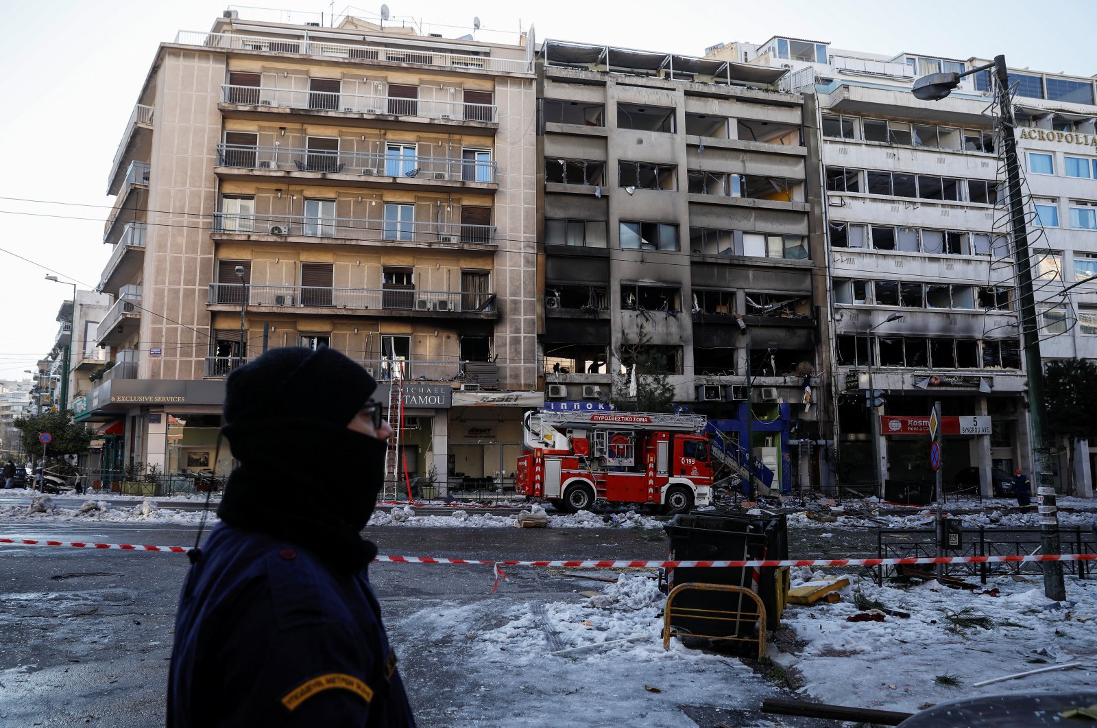 A police officer stands guard opposite damaged buildings after a blast in Athens, Greece, Jan. 26, 2022. (Reuters Photo)