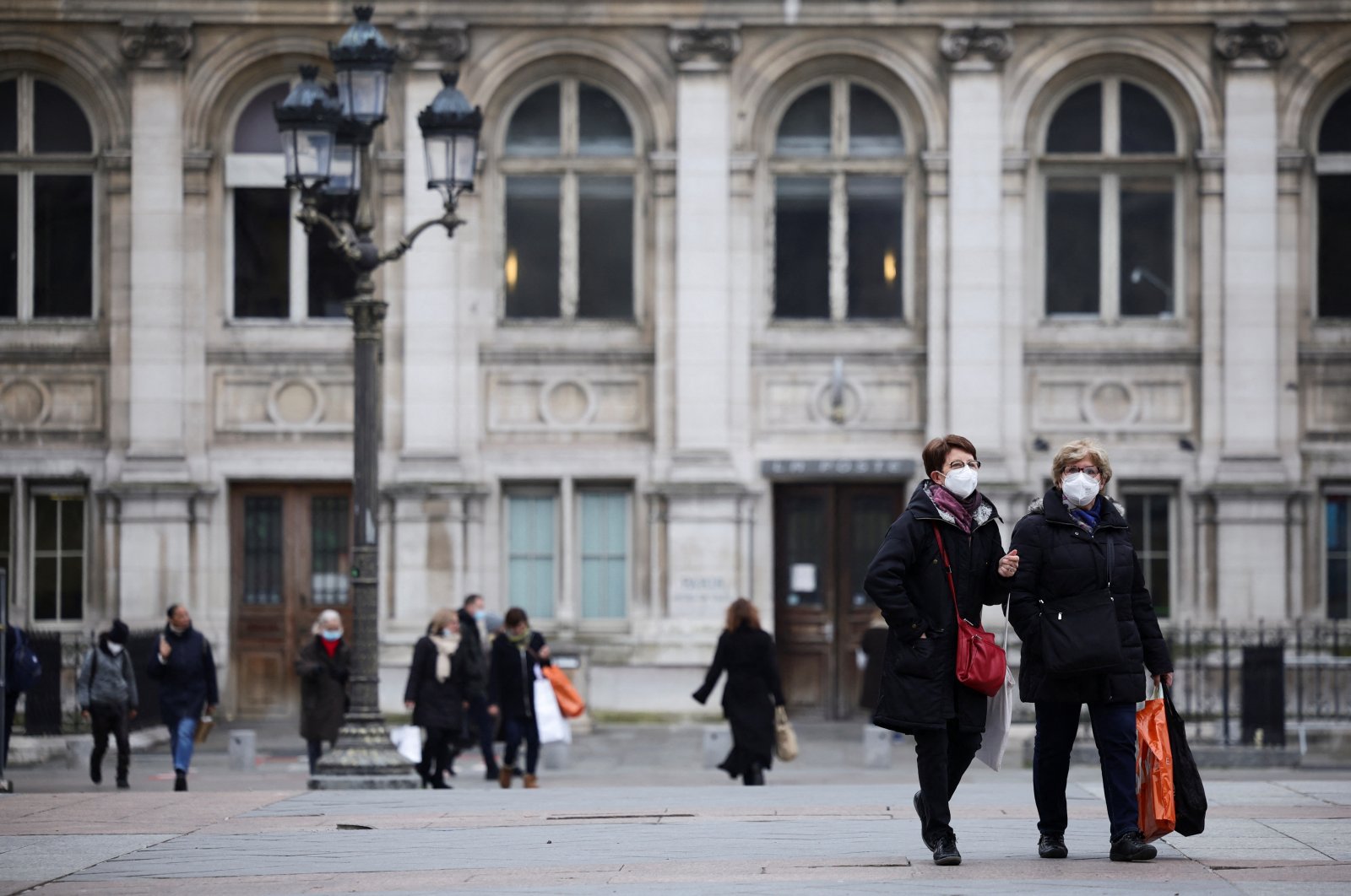 Women wearing protective face masks walk in front of Paris Town Hall, amid the rise of coronavirus cases due to the Omicron variant, in Paris, France, Jan. 25, 2022. (Reuters Photo)
