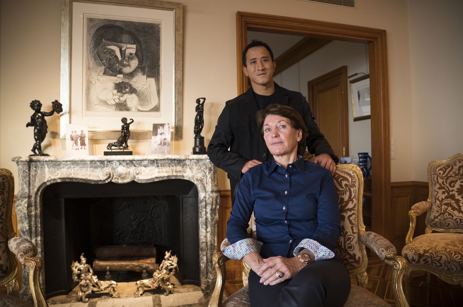 Marina Picasso, granddaughter of artist Pablo Picasso, sits and poses for a photo with her son Florian Picasso during an interview in Cologny near in Geneva, Switzerland, Jan. 25, 2022. (AP Photo)