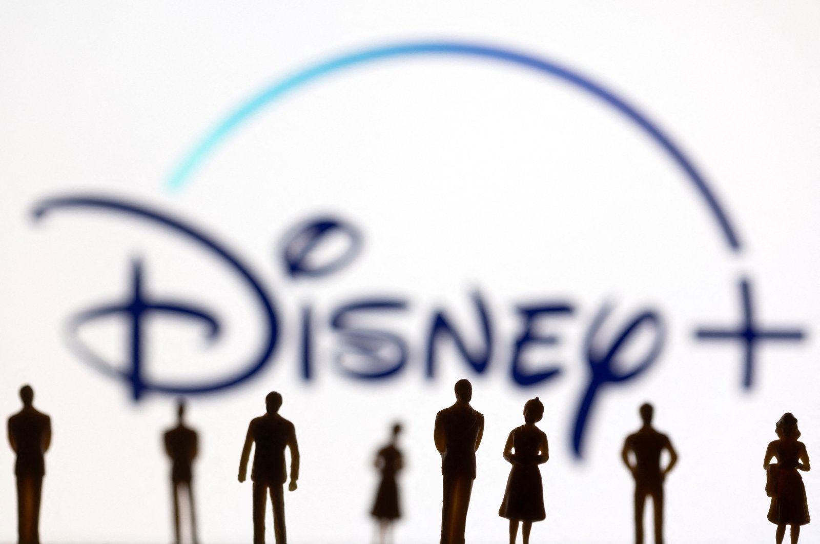 Toy figures of people are seen in front of the displayed Disney  logo, Jan. 20, 2022. (Reuters Photo)