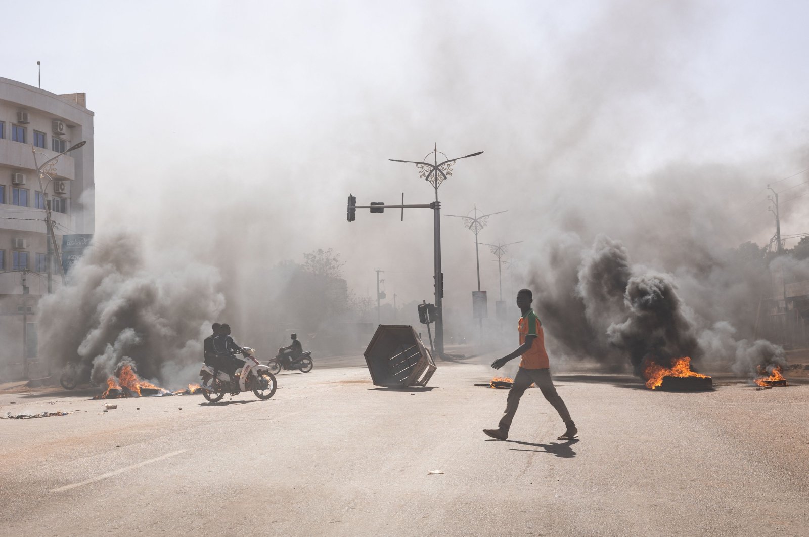 A man crosses through burning barricades in the central avenues in Ouagadougou where a group of young demonstrators supporting the role of the army protested against President Marc Christian Kabore, Burkina Faso, Jan. 23, 2022. (AFP Photo)