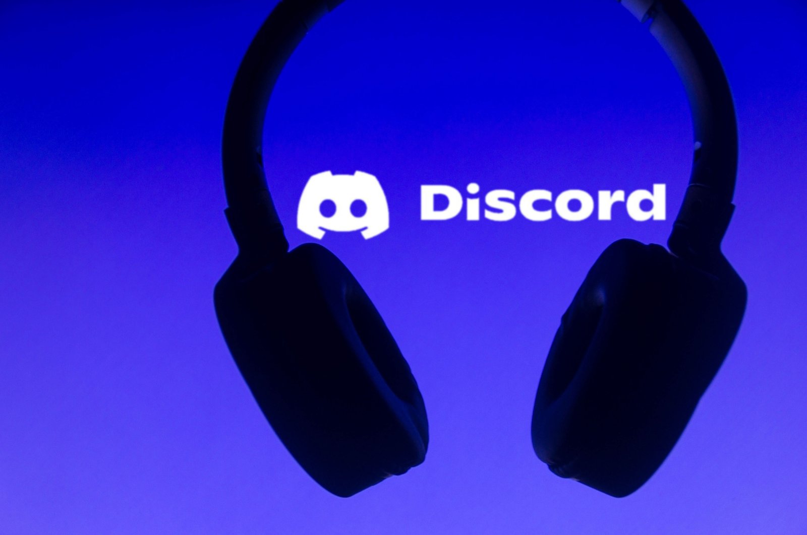 In this photo illustration, the Discord logo is displayed along with a headset. (Reuters Photo)