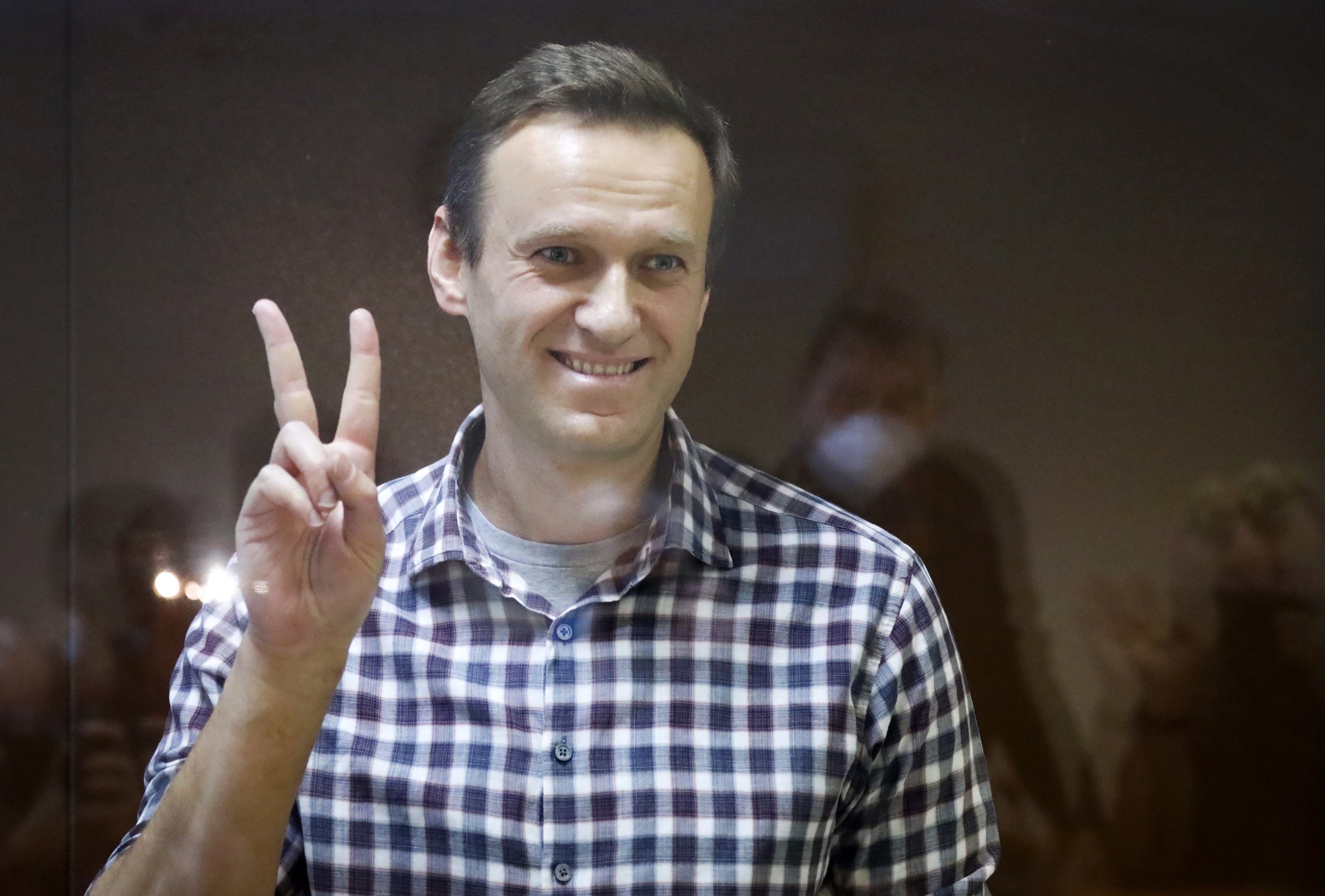 Pemimpin oposisi Rusia Alexei Navalny memberi isyarat saat dia berdiri di dalam sangkar di Pengadilan Distrik Babuskinsky di Moskow, Rusia, 20 Februari 2021. (AP)