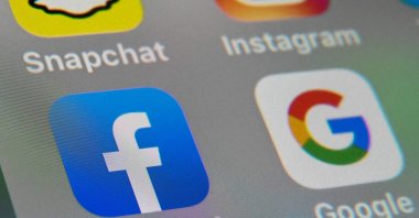 The logos of mobile apps Facebook and Google are displayed on a tablet in Lille, France, Oct.1, 2019. (AFP Photo)