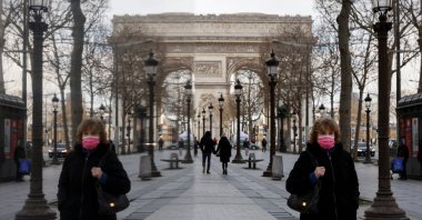 A woman wearing a protective face mask walks near the Arc de Triomphe on the Champs Elysees Avenue in Paris amid the coronavirus outbreak in France, Jan. 21, 2022. (Reuters Photo)
