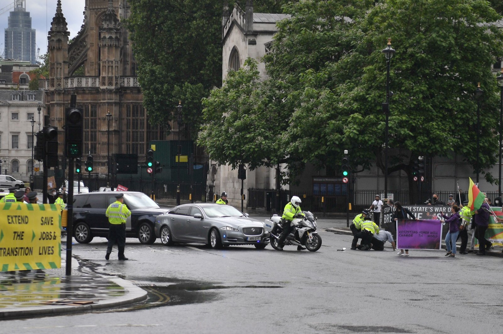 A protester from a pro-PKK demonstration is stopped and detained by police officers as he ran towards the car of Britain&#039;s Prime Minister Boris Johnson (C) as it was leaving with a police escort from the Houses of Parliament in London on June 17, 2020. (AFP Photo)