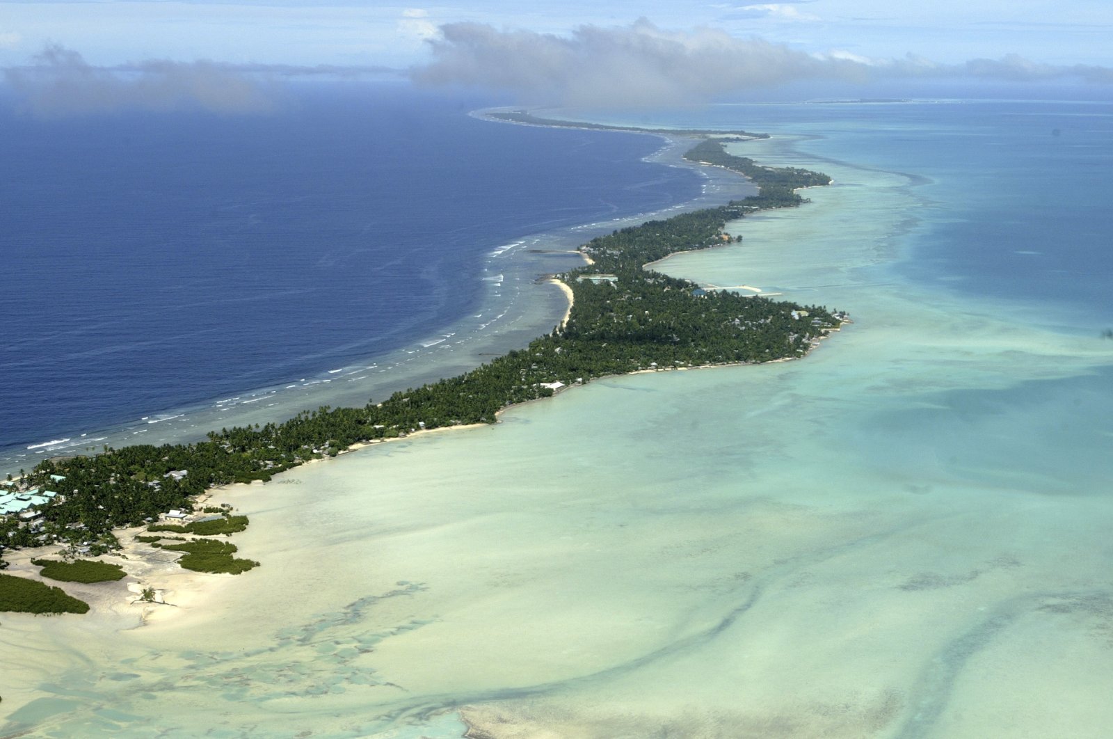Kiribati and several other small Pacific nations were among the last on the planet to have avoided any virus outbreaks, thanks to their remote locations and strict border controls, Tarawa atoll, Kiribati, March 30, 2004. (AP Photo)