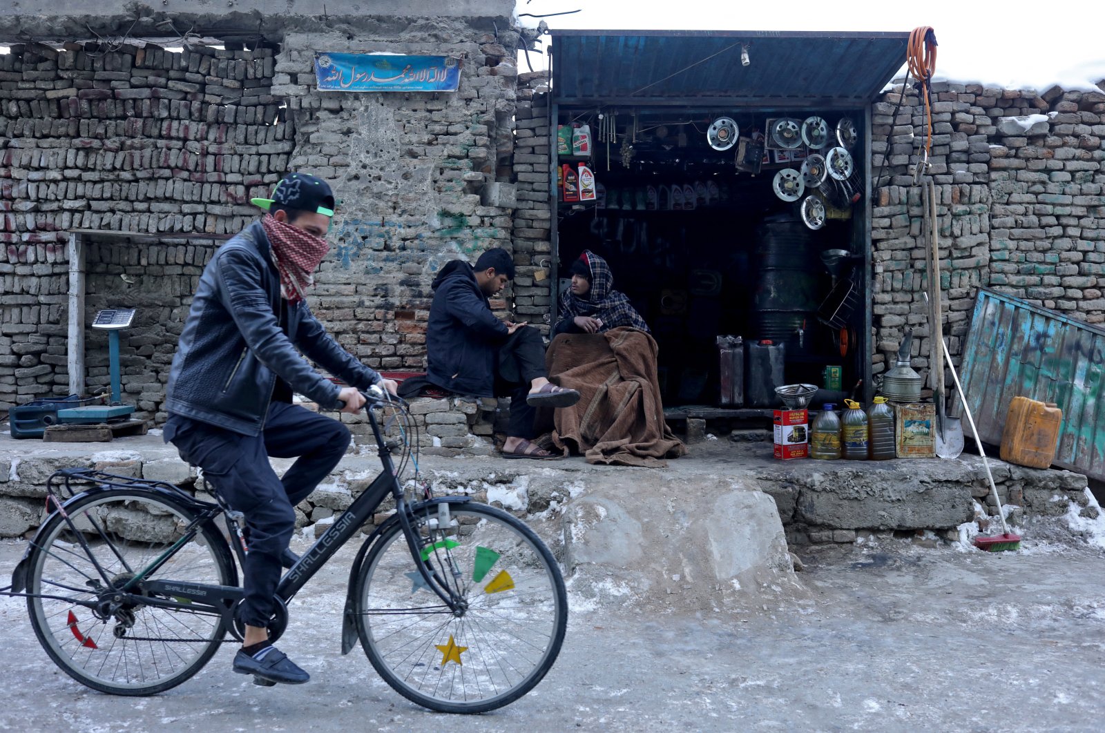 An Afghan man rides his bicycle past a shop selling fuel in Kabul, Afghanistan, Jan. 27, 2022. (Reuters Photo)