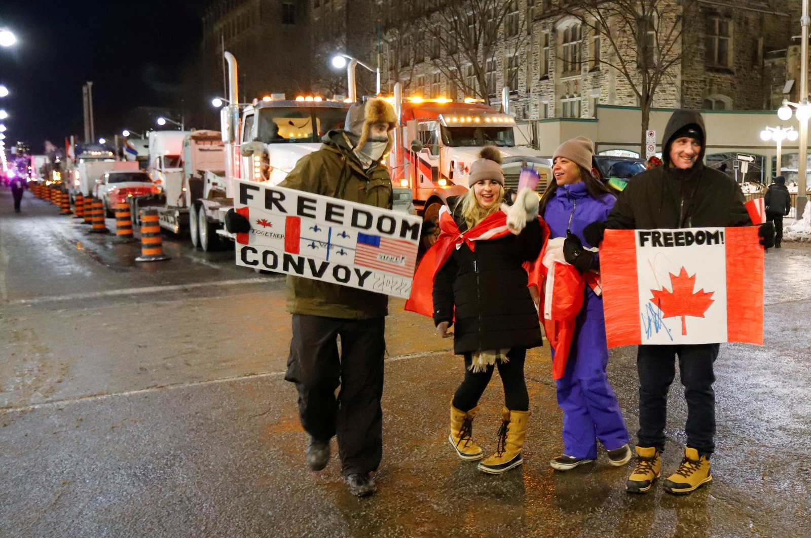 Supporters of a trucker convoy to protest coronavirus disease (COVID-19) vaccine mandates for cross-border truck drivers walk past a row of trucks on Parliament Hill in Ottawa, Ontario, Canada, Jan. 28, 2022. (Reuters File Photo)