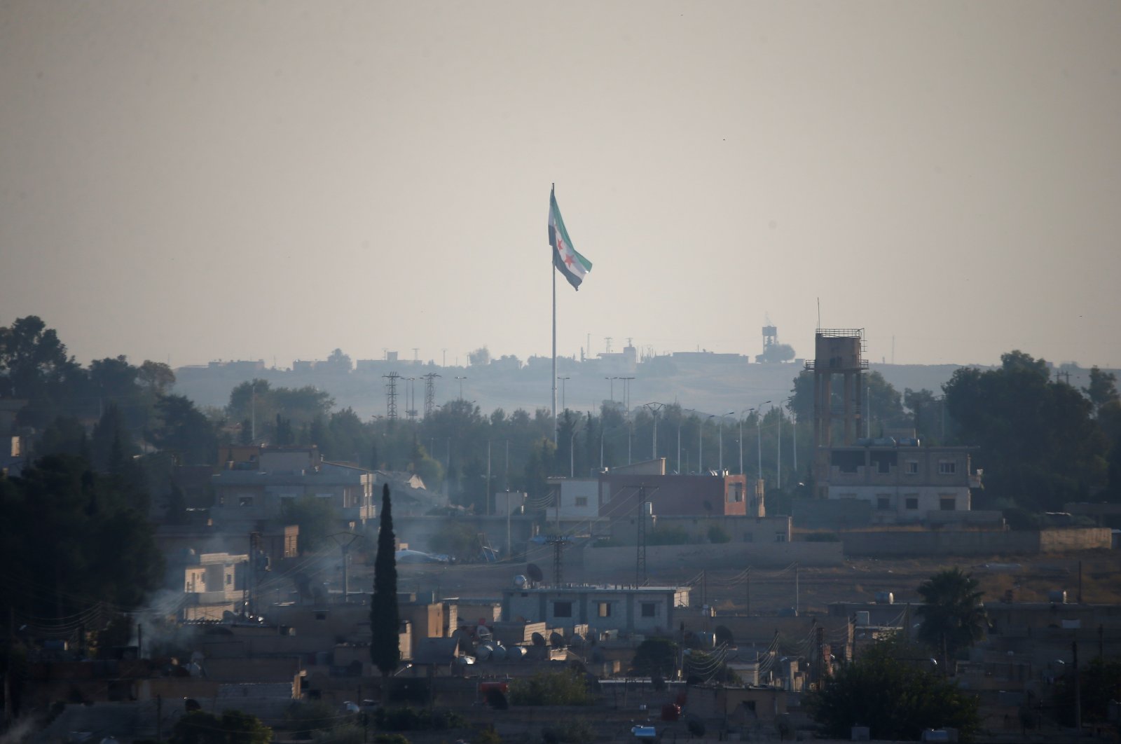 A Syrian opposition flag flutters in the Syrian town of Tal Abyad, as seen from the Turkish border town of Akçakale, in Şanlıurfa province, Turkey, Oct. 30, 2019. (Reuters File Photo)