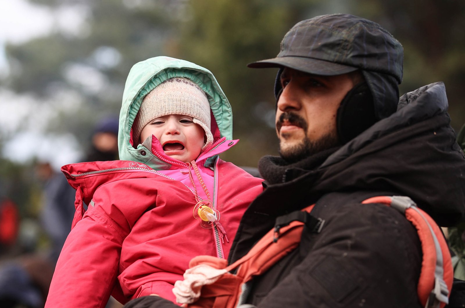 A man holds a child on the Belarusian-Polish border on Nov. 8, 2021. (TASS via Getty Images)