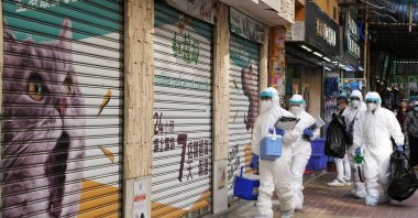 Officers in protective suits walk outside a closed pet shop in Mong Kok district after a hamster cull was ordered to curb the COVID-19 outbreak, in Hong Kong, Jan. 19, 2022. (Reuters Photo)