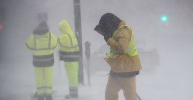 A worker shields himself from blowing snow and wind as Winter Storm Kenan bears down on Boston, Massachusetts, U.S., Jan. 29, 2022. (Getty Images / AFP)