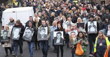 People take part in a march to commemorate the 50th anniversary of the "Bloody Sunday" shootings with the front rank holding photographs of some of the victims in Londonderry, Northern Ireland, Jan. 30, 2022. (AP Photo)